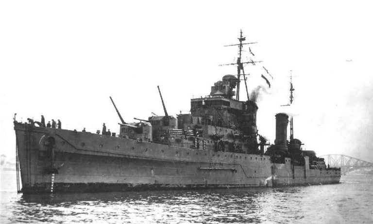 Historic warship on calm waters, displaying military features and flags.